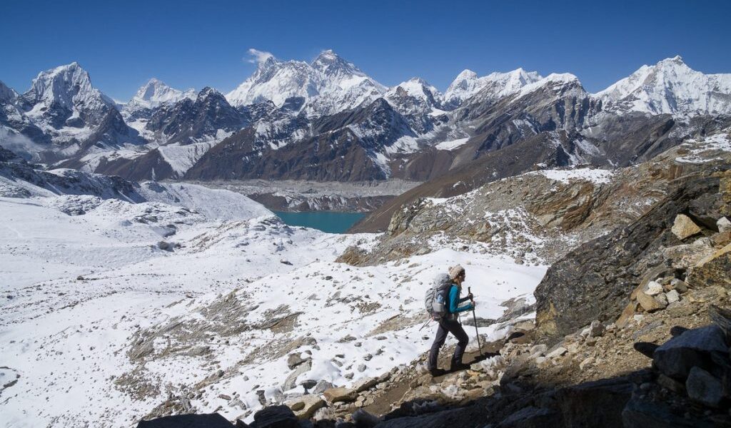 "Adventurers traversing the Khumbu Three Passes with towering peaks and rugged terrain."